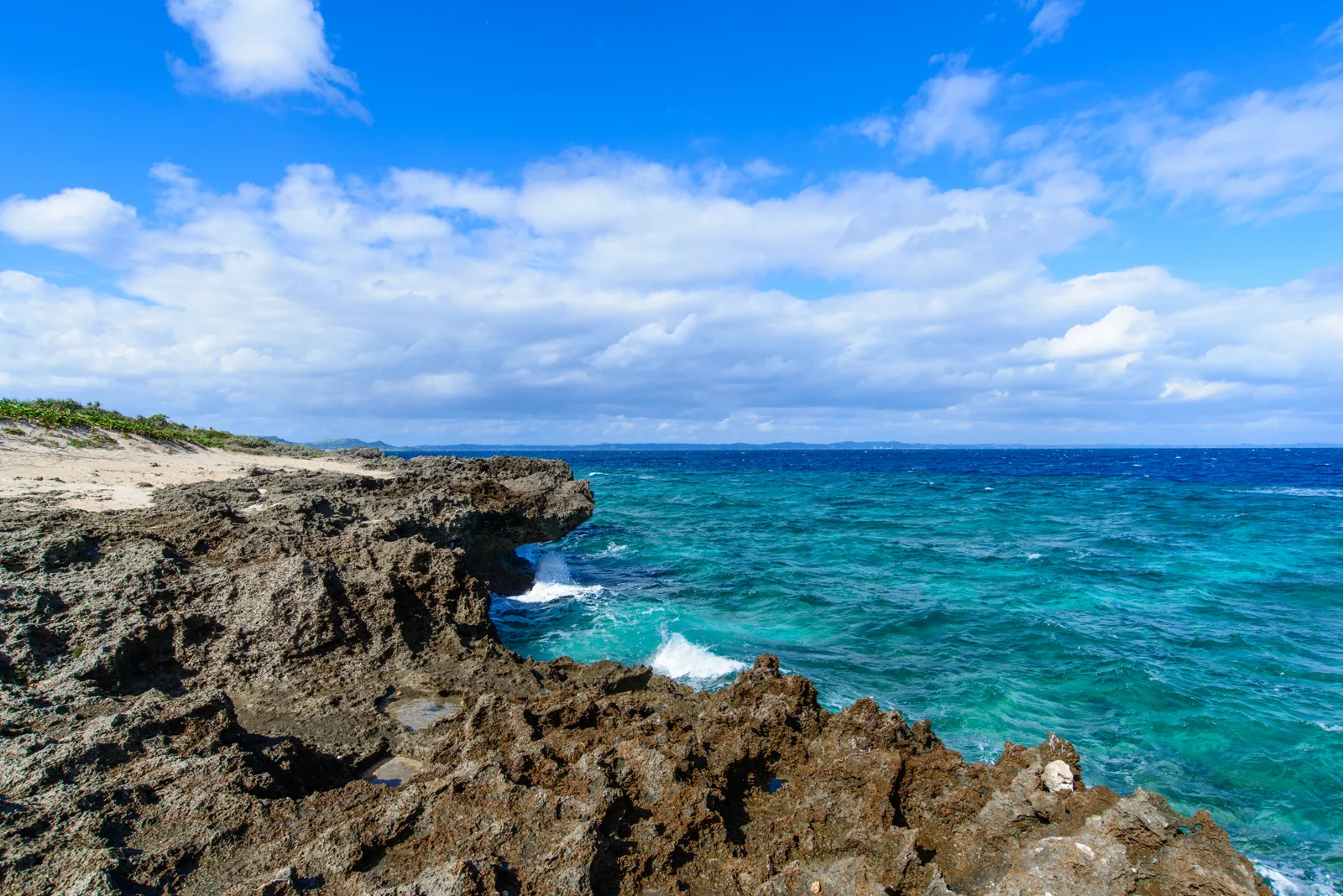 岬から海を望む旅人